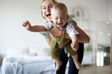 pretty girl babysitting adorable toddler, having fun in stylish interior. portrait of beautiful happ
