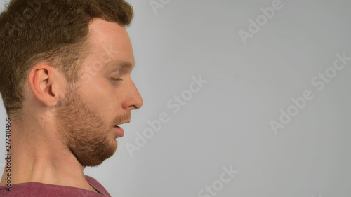 Close Up Face In Profile Caucasian Guy With Red Hair Sneezing