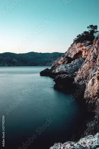 Foto-Schiebegardine mit Schienensystem - Long exposure shot with blurry soft ocean water and the rock stone coastline on a vacation summer day. Port d' Andratx, Port Andratx, Mallorca Spain Balearics (von Ricardo)
