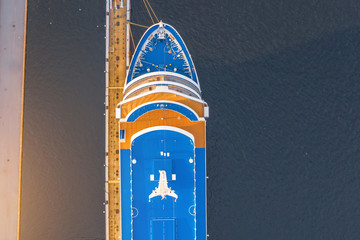 Wall Mural - Nose of a cruise passenger liner at the pier in the river port, aerial top view.