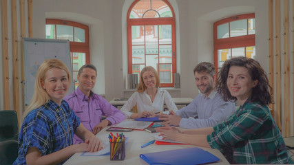 Poster - Portrait successful young business team in contemporary office. Diverse group of people at the meeting or brainstorming looking at the camera. Casual professional women and men sitting in boardroom.