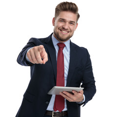 Poster - Cheerful businessman pointing and holding a tablet