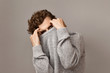 © Anatoliy Karlyuk - Men’s fashion, wear, clothing, style and people concept. Horizontal isolated image of confident handsome young male with curly reddish hair hiding under stylish sweater, having mysterious look
