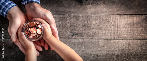 Fotografía Hands Of Father Giving Jar Of Coins To Child On Wooden Table Background - Inheri