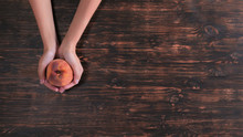 Unrecognizable Woman Holding Fruits Over The Wooden Table. Close Up Female Hands With Peach