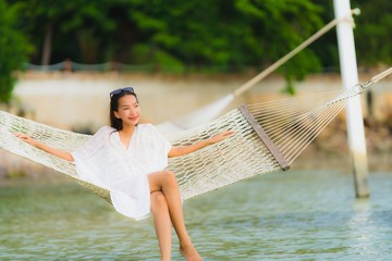 Portrait beautiful young asian woman sitting on hammock around sea beach ocean for relax