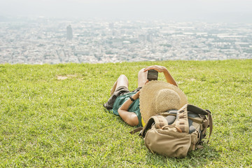 Canvas Print - woman lie on grassland and using cellphone