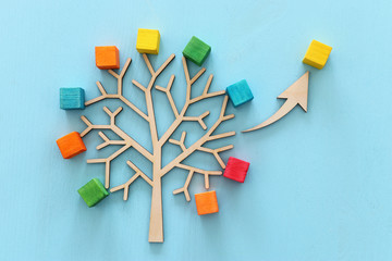 Business image of wooden tree with colorful cubes over blue table, human resources and management concept