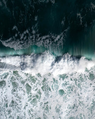Wall Mural - Aerial view of a waves crashing and rolling in the ocean.