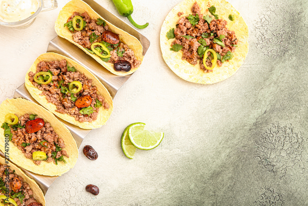 Stand with tasty fresh tacos on light background