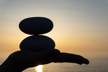 pebble turret on the palm. romantic evening on the coast of the sea. beautiful sunset