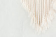 Close up of cotton macrame panel fringe in a minimalistic scandinavian wall. Texture. Background.