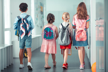 girls and boy wearing nice bright backpacks going to the lesson