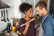© Rido - Multiethnic couple tasting food from wooden spoon