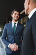© Drobot Dean - Portrait closeup of two professional businessmen partners shaking hands outside job center during working meeting