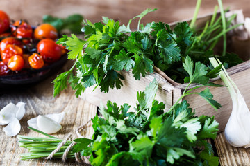 Wall Mural - Crate of freshly picked organic  parsley, roasted cherry  tomatoes, and fresh garlic on rustic  table