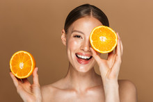 Image Closeup Of Healthy Half-naked Woman Smiling And Holding Two Orange Parts