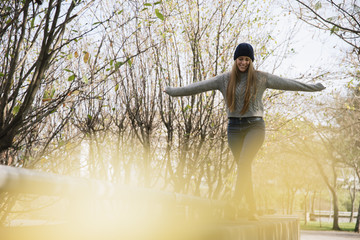 Smiling young woman balancing in the park