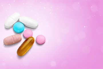 Canvas Print - pills and capsules on a pink background close-up