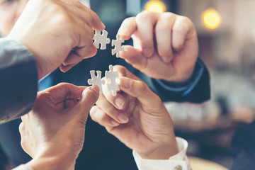 businessman team work holding two jigsaw connecting couple puzzle piece for matching to goals target