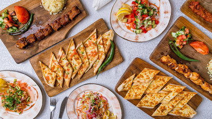 Wall Mural - Assorted Turkish foodset on table. Turkish pide with cheese, Turkish pide with vegetables, vegetable salad, turkish kebabs from beef and chicken.