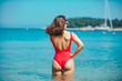 © phpetrunina14 - woman standing in sea in the middle in red swimming suit. view from behind. sexy ass