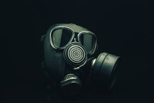 Gas Mask On A Black Table And Dark Background.