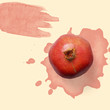 Red pomegranate on the pastel background with red watercolor splash