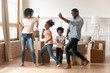 Happy african american parents and children dancing celebrating moving day