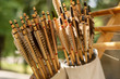 Many handcrafted arrows in a brown leather quiver full with arrows in crafted in medieval style, each arrow with different brown color on the feather. Close up, selective focus