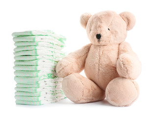 Wall Mural - stack of diapers and teddy bear on white background. baby accessories