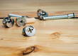 © Demianastur - Construction tools. The screws, nuts and bolts on wooden background. Repair home improvement concept
