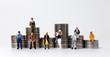 Coin stacks and various miniature people. The concept of the wage gap according to occupation.