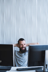 successful business project. happy male engineer sitting at his workplace, smiling. copy space.