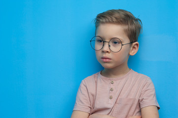 Wall Mural - Little cute boy in glasses posing thoughtfully