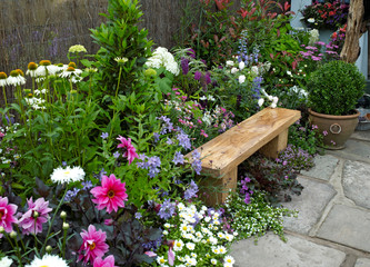 Wall Mural - A traditional thatched cottage garden designed to creat a calming and relaxing space with colourful flowers and seating