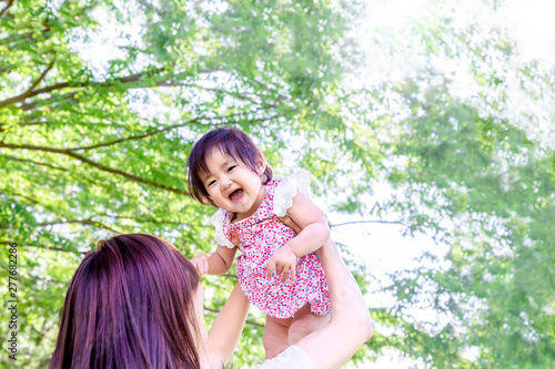 新緑の木漏れ日の下 赤ちゃんを高い高いをしてあやすお母さん 家族 母子 親子 幸せ 愛 育児 子育てイメージ Kwiaty Obrazy Na Plotnie