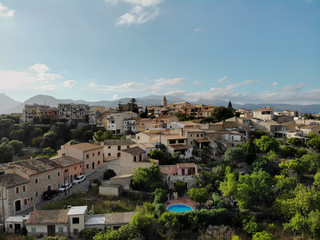 Aerial photo drone point of view image Campanet town hillside residential old ancient houses building exterior situated in the northeast of Majorca Island, Spain