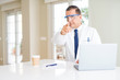 © Krakenimages.com - Middle age scientist man wearing professional glasses working using laptop pointing with finger to the camera and to you, hand sign, positive and confident gesture from the front