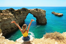 Young Beautiful Woman Enjoying The Panoramic Top View Of Rocky Beaches With Cliffs Somwhere, Somwhere In Algarve, Portugal. Atlantic Ocean Shore Background. Copy Space For Text.
