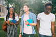 © Iryna - Group of cheerful students with backpack holds books walking at the campus outdoors, close up. Youth Friendship Together Smiling Happiness Concept. Sun glare effect