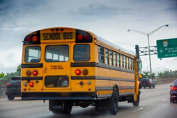 Wall Mural - School bus on the highway in Miami on a cloudy day