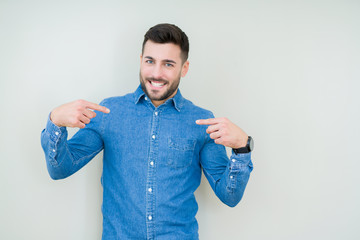 Young handsome man over isolated background looking confident with smile on face, pointing oneself with fingers proud and happy.