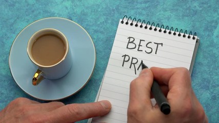 Canvas Print - best practice concept - man hand writing a note with a black marker in a spiral notebook, overhead v
