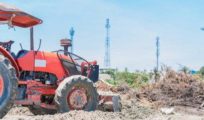 Wall Mural - Close up of small bulldozer scoop moving earth pushing the ground for land prepare. Bulldozer in work at construction site.