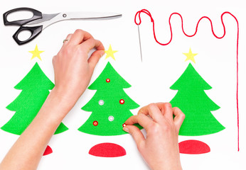 Female hands making Christmas greeting cards on white