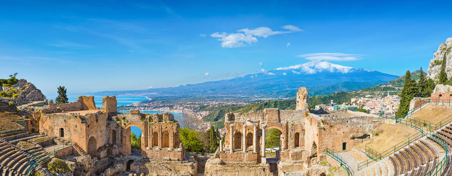 ancient greek theatre in taormina on background of etna volcano, italy