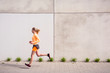 © Tandem Stock - Olympia Park, Munich, Bavaria, Germany: A young female runner running through the olympic village in the morning.
