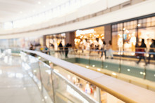 Blurred big sales on Black Friday. A long light floor in the mall with shops for buyers. Sale of clothing in a modern shopping center. The main background for the design. Shopping. Copyspace