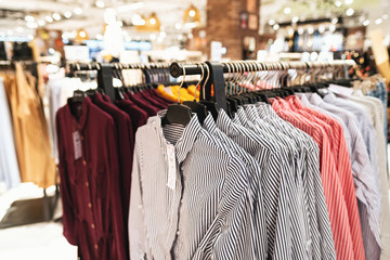 Blurred big sales on Black Friday. On sale at a clothing store in a modern shopping mall. Beautifully laid out things on hangers. Basic background for design